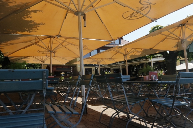 Die großen Sonnenschirme spenden Schatten im Biergarten.